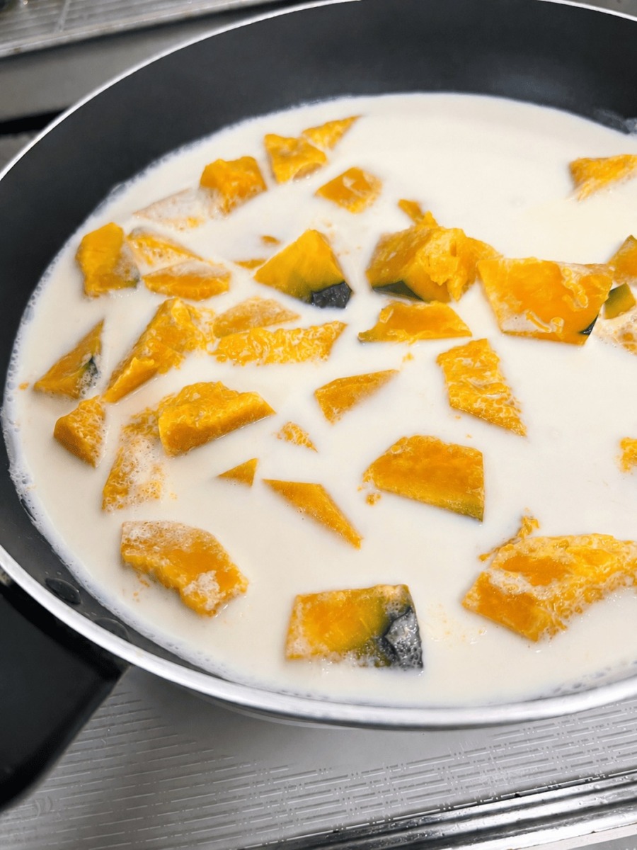 鍋でかぼちゃと牛乳を煮ている様子。落とし蓋にアルミホイルを使用