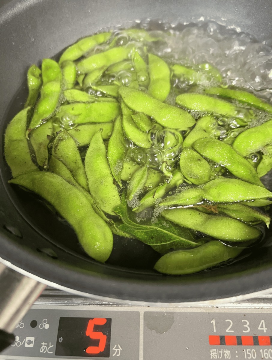 収穫した黒枝豆を鍋で塩ゆでしている様子